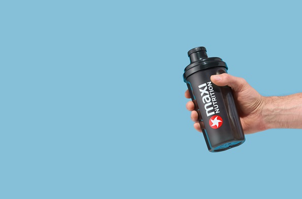 maxinutrition-shaker-schwarz-500ml-in-der-hand-gehalten-vor-blauem-hintergrund