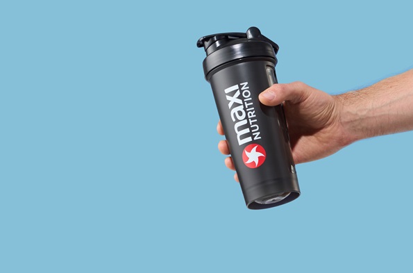 maxinutrition-shaker-schwarz-700ml-in-der-hand-gehalten-vor-blauem-hintergrund
