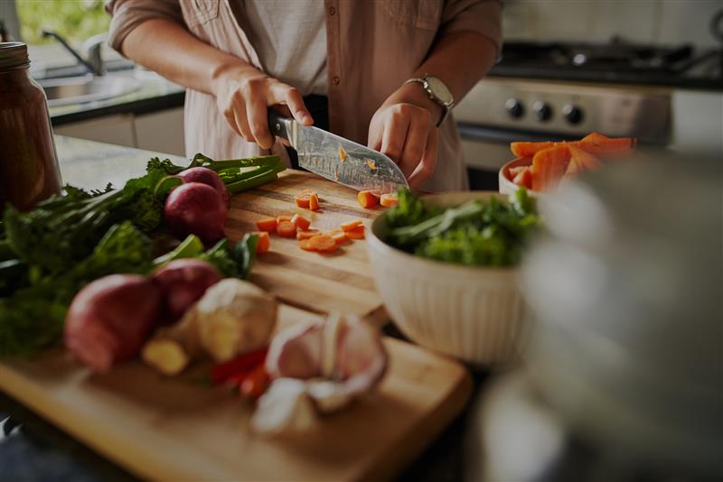 maxinutrition_vegane_ernährung__so_startest_du_ein_pflanzliches_leben_frau_am_Gemüse-schneiden