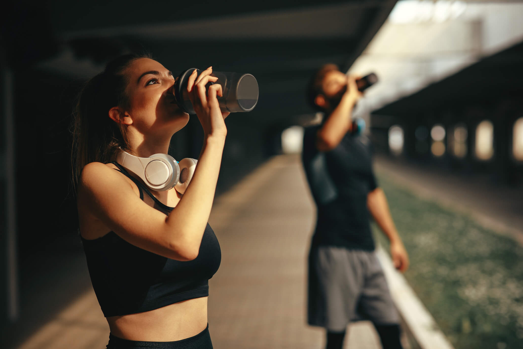 maxinutrition_was_hilft_gegen_muskelkater_mann_und_frau_trinken_einen_shake